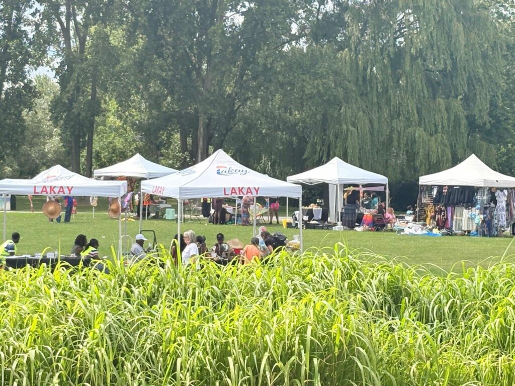 Les kiosques Lakay du Carnaval du monde vus à travers la végétation du parc